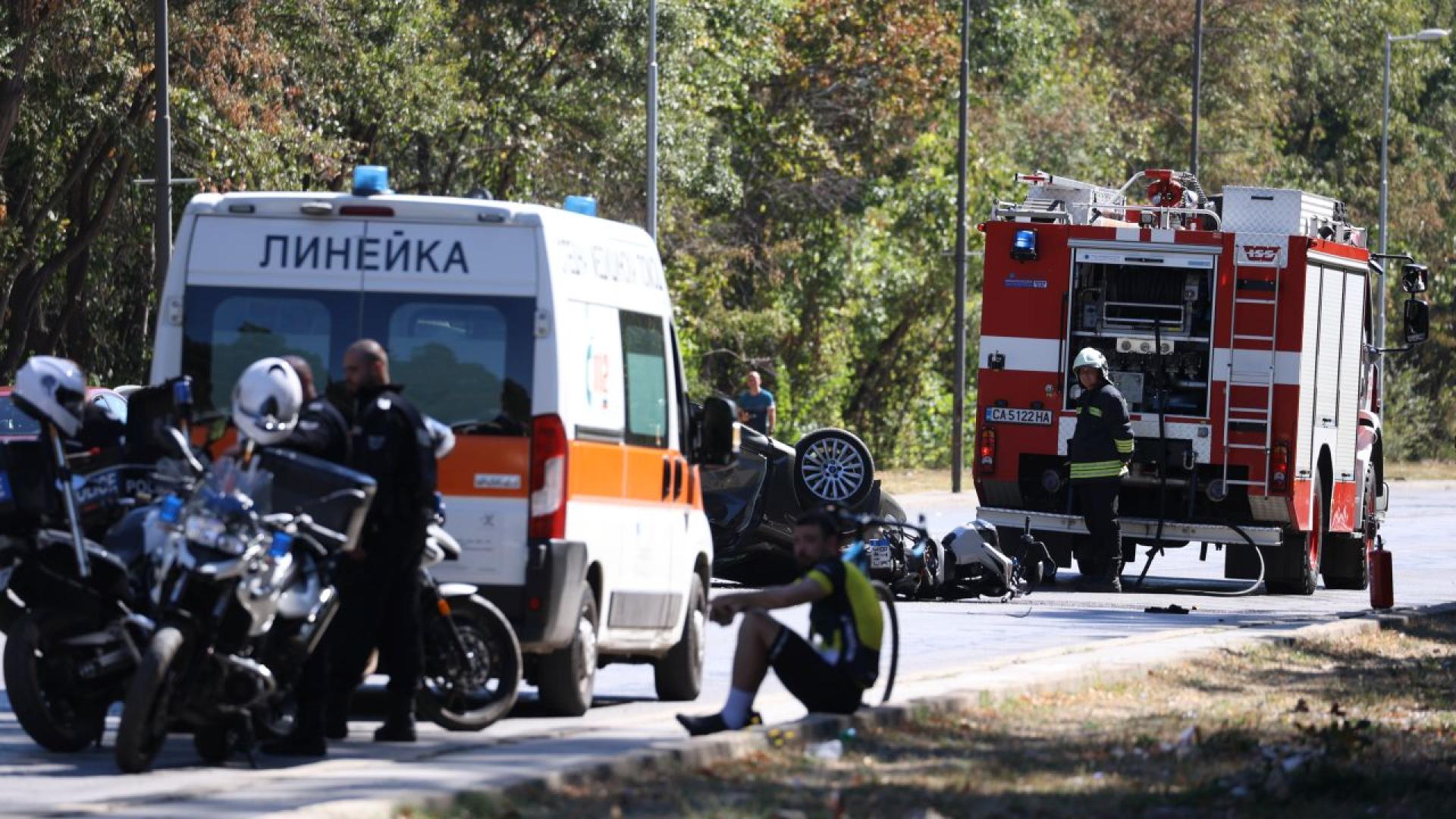 Miejsce wypadku drogowego — karetka, wóz strażacki i policja